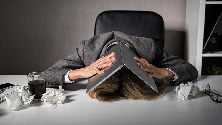 Executive placing open laptop over her head and hiding from the world